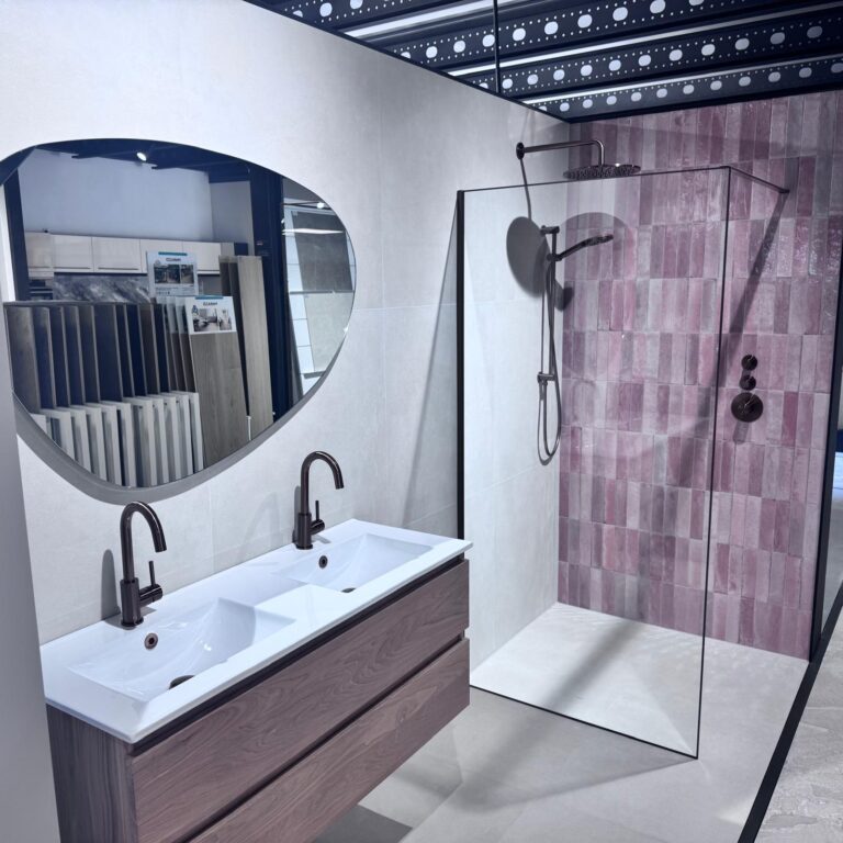 Badkamermeubel met dubbele wastafel en ronde spiegel in de showroom van Thuis in Tegels & Sanitair